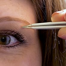 Woman closeup of eye holding ZB white tweezers tweezing eyebrow hair